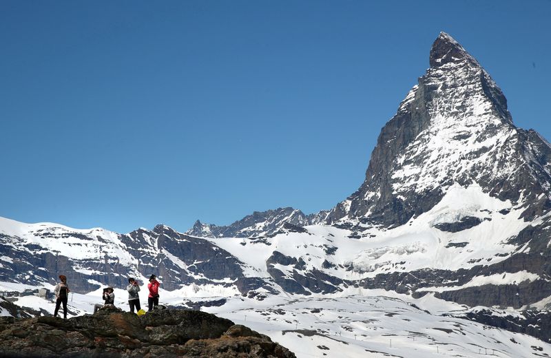 Tourists take a picture in front of the Matterhorn mountain at the Gornergrat in Zermatt, Switzerland, June 2, 2019. Five skiers have been found dead on a mountain close to the luxury ski resort of Zermatt. 